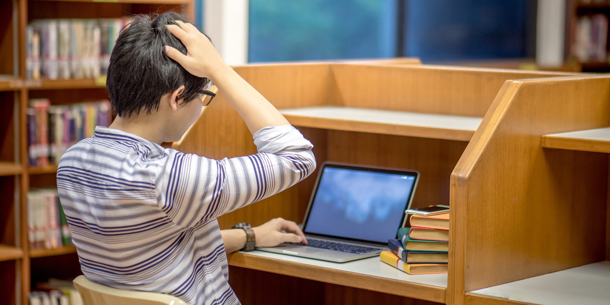 Young Asian university student in library